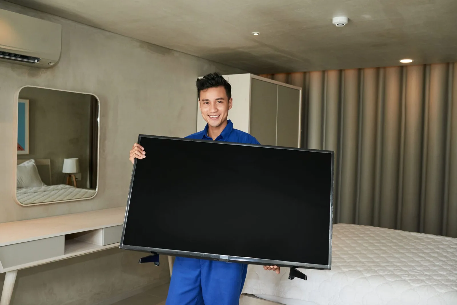 Televisor montado en un soporte de pared en la sala de una vivienda