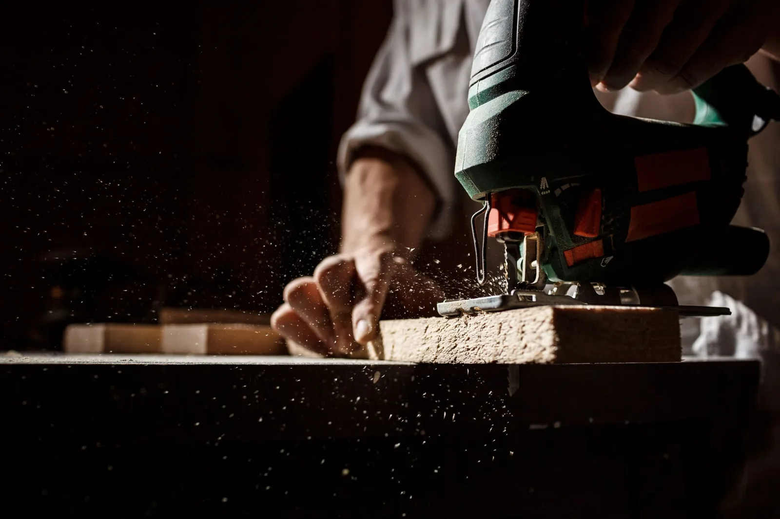 Carpintero midiendo y trabajando madera para un clóset a la medida en un taller