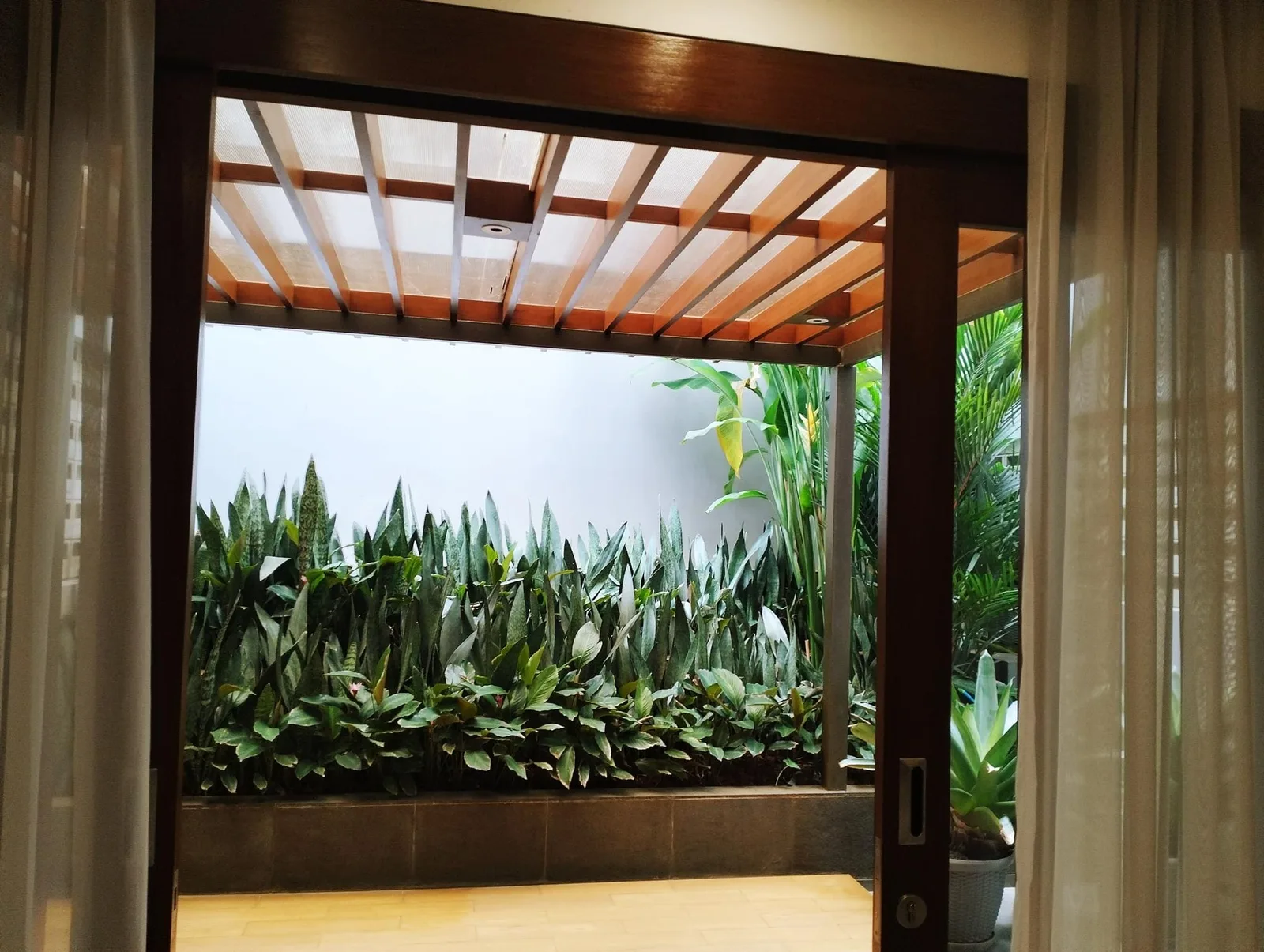 Pérgola de madera instalada en una terraza exterior con zona de descanso
