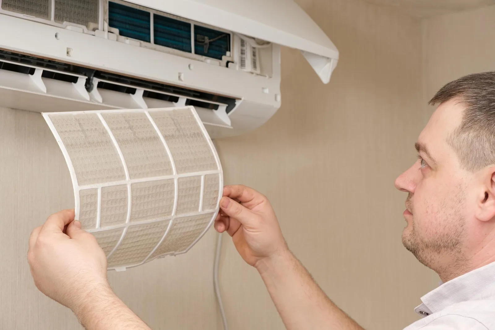 Técnico retirando el filtro sucio de un aire acondicionado para mantenimiento