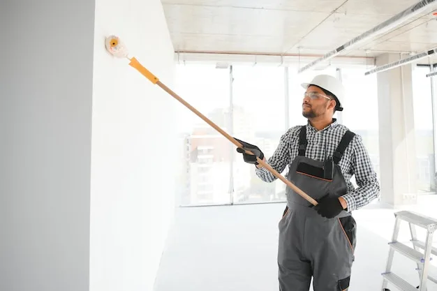 Pintor profesional pintando una pared blanca con rodillo en Medellín