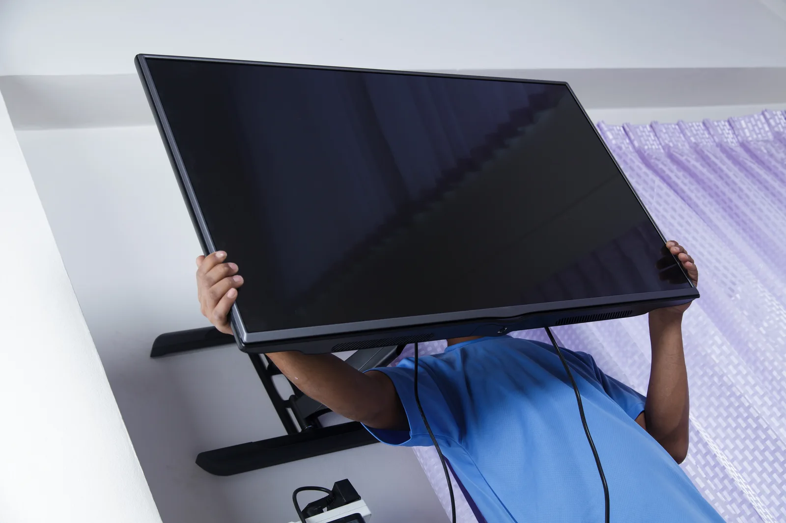 Soporte móvil para TV con ruedas y televisor plano en una sala de conferencias